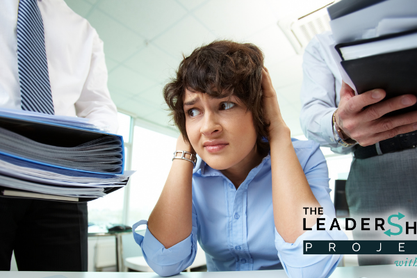 Overworked young office worker being given more work