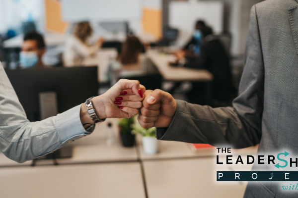 Two coworkers, female and male, fist bump in agreement