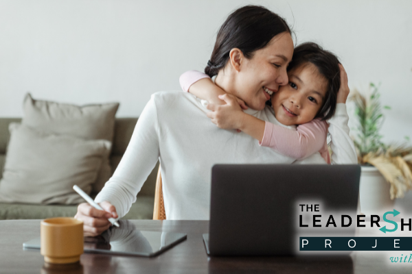 Mother hugs daughter while working
