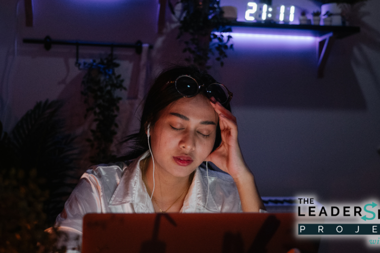 Female worker looking tired in front of a computer screen late at night